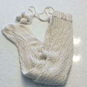 Tall Ugg socks with pom poms and gold thread.